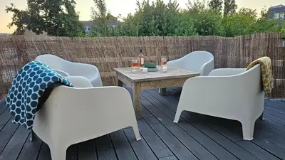 a patio with a table and chairs on a deck at Amsterdam ZaanseSchans House in Krommenie