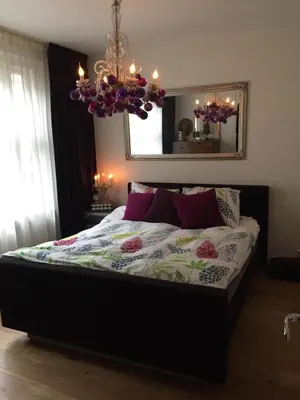 a bedroom with a large bed with a chandelier at Treasure in Amsterdam