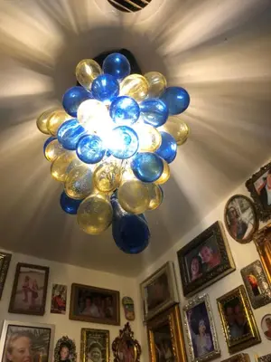 a chandelier with blue and gold balloons on a ceiling at Treasure in Amsterdam