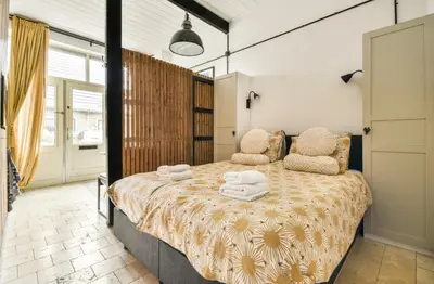 a bedroom with a large bed with towels on it at Studio Pien Zandvoort in Zandvoort