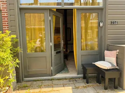 a door to a house with a bench and a porch at Studio Pien Zandvoort in Zandvoort