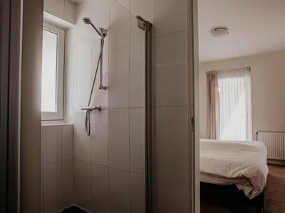 a bathroom with a shower and a bed at Apartment Westergeest 2 by Interhome in Uitgeest