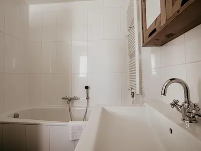 a white bathroom with a sink and a tub at Apartment Westergeest 2 by Interhome in Uitgeest