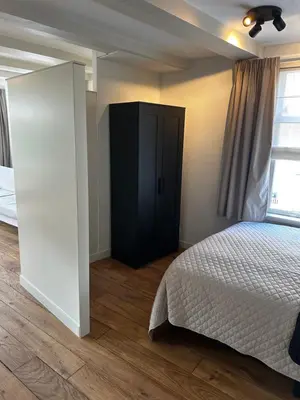 a bedroom with a bed and a black cabinet at Boutique LaBeau in Amsterdam