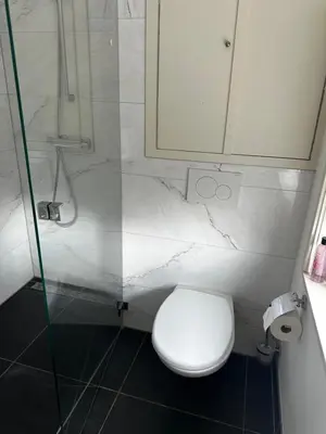 a bathroom with a toilet and a glass shower at Boutique LaBeau in Amsterdam