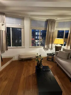 a living room with a couch and two windows at Boutique LaBeau in Amsterdam