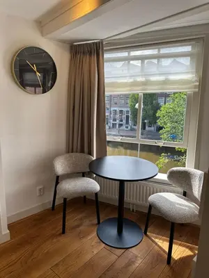 a table and two chairs in a room with a window at Boutique LaBeau in Amsterdam