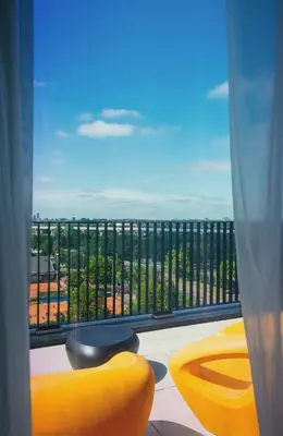 a room with a view of a balcony with yellow furniture at Jaz in the City Amsterdam in Amsterdam
