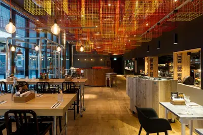 a restaurant with tables and chairs and lights at Jaz in the City Amsterdam in Amsterdam