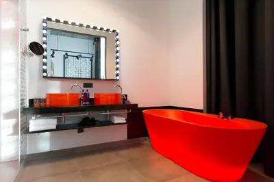 a red tub in a bathroom with a mirror at Jaz in the City Amsterdam in Amsterdam