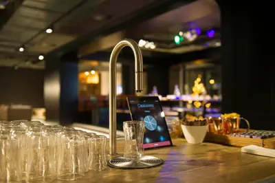 a bar with a sink and glasses on a counter at Jaz in the City Amsterdam in Amsterdam