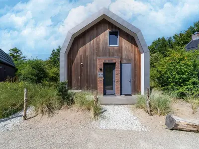 a wooden building with a door in the middle at Holiday home Waterland for six Person in Egmond aan den Hoef