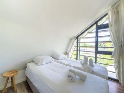 two beds in a room with a large window at Holiday home Waterland for six Person in Egmond aan den Hoef