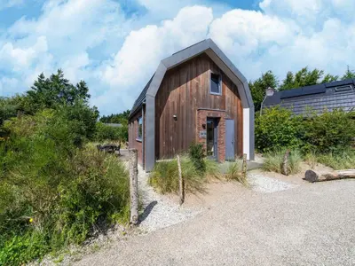 a small wooden building with a gambrel roof at Holiday home Waterland for six Person in Egmond aan den Hoef