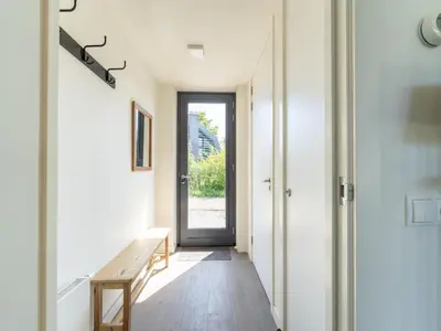a hallway with a wooden bench and a door at Holiday home Waterland for six Person in Egmond aan den Hoef