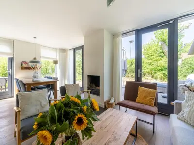 a living room with a table and a fireplace at Holiday home Waterland for six Person in Egmond aan den Hoef