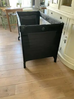 a black chair in a kitchen with a wooden floor at De Verwondering Privé etage met 2 slaapkamers in Gouda