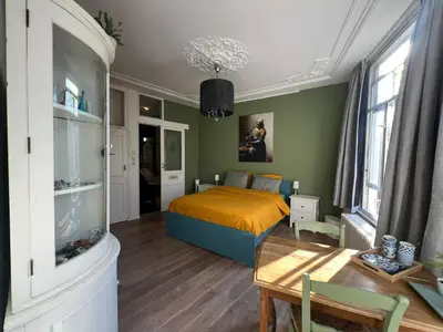a bedroom with a bed and a table in it at De Verwondering Privé etage met 2 slaapkamers in Gouda