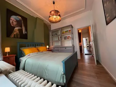 a bedroom with a bed and a painting on the wall at De Verwondering Privé etage met 2 slaapkamers in Gouda