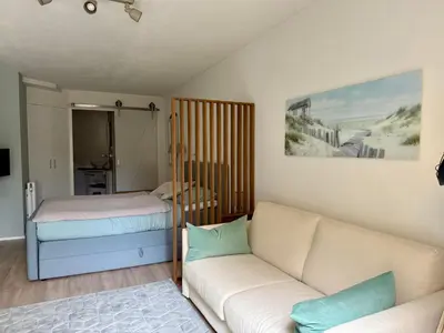 a living room with a couch and a bed at Zeegroen in Zandvoort
