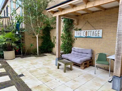 a patio with a purple couch and two chairs at Zeegroen in Zandvoort