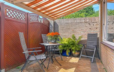 a patio with a table and chairs and a fence at 2 Bedroom Beach Front Home In Egmond Aan Zee in Egmond aan Zee