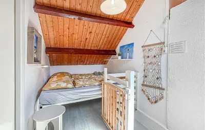 a small bedroom with a bed and a wooden ceiling at 2 Bedroom Beach Front Home In Egmond Aan Zee in Egmond aan Zee