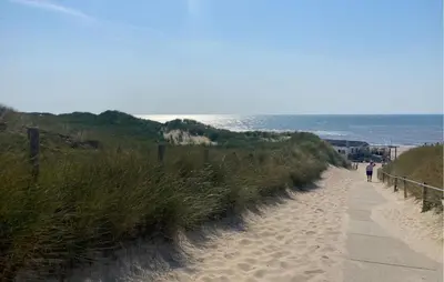a person walking down a sandy path to the beach at 2 Bedroom Beach Front Home In Egmond Aan Zee in Egmond aan Zee