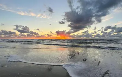 a sunset on a beach with the ocean at 2 Bedroom Beach Front Home In Egmond Aan Zee in Egmond aan Zee