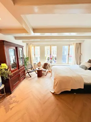 a large bedroom with a large bed and windows at History and luxury in Amsterdam