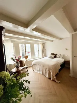 a bedroom with a large bed and some windows at History and luxury in Amsterdam