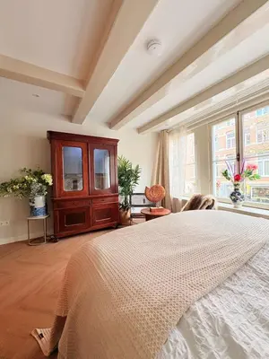 a bedroom with a large bed and a large window at History and luxury in Amsterdam