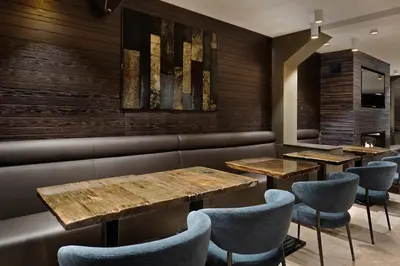 a restaurant with wooden tables and chairs at Amsterdam Forest Hotel in Amstelveen