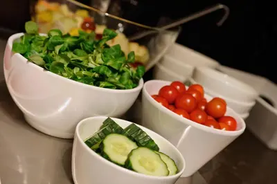 a group of bowls of vegetables and tomatoes on a table at Amsterdam Forest Hotel in Amstelveen