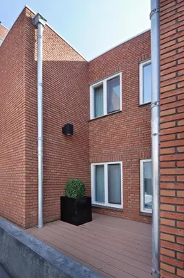 a brick building with a potted plant in front of it at Amsterdam Forest Hotel in Amstelveen