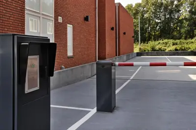 a barrier in a parking lot next to a brick building at Amsterdam Forest Hotel in Amstelveen