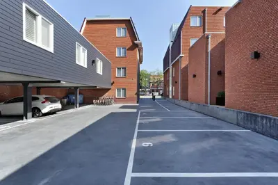 an empty parking lot between two brick buildings at Amsterdam Forest Hotel in Amstelveen