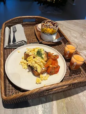 a breakfast plate of food on a wicker table at Puur Schoorl in Schoorl