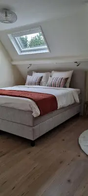 a bedroom with a large bed with a window at Puur Schoorl in Schoorl