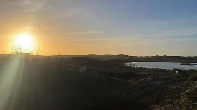 a sun setting over a body of water at Puur Schoorl in Schoorl