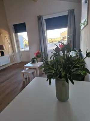 a vase with flowers on a table in a living room at B&Boerderij De Veldmuis in Eemdijk