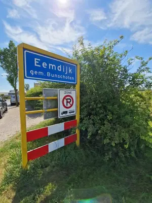 a sign with a no parking sign next to a fence at B&Boerderij De Veldmuis in Eemdijk