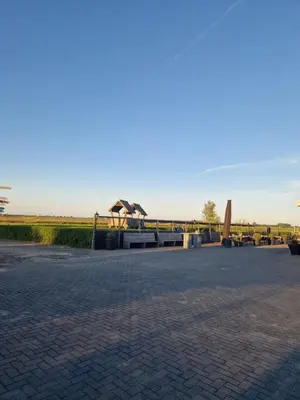 a park with a bench and a bridge in the background at B&Boerderij De Veldmuis in Eemdijk