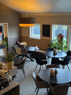 a waiting room with tables and chairs at B&Boerderij De Veldmuis in Eemdijk