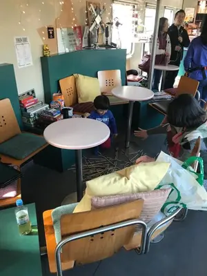 a group of tables and chairs with two children sitting at them at Train Lodge Amsterdam in Amsterdam