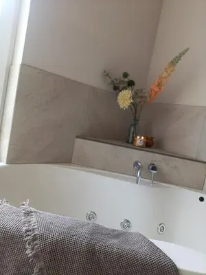 a bathroom with a bath tub with a mirror at Mediterranean apartment with home theater in Bodegraven