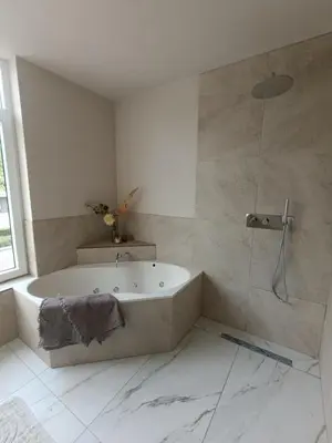 a white bathroom with a tub and a shower at Mediterranean apartment with home theater in Bodegraven