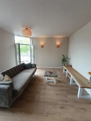 a living room with a couch and a table at Mediterranean apartment with home theater in Bodegraven