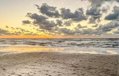 a sunset on the beach with the ocean at Nice Home In Dirkshorn With Wifi in Dirkshorn