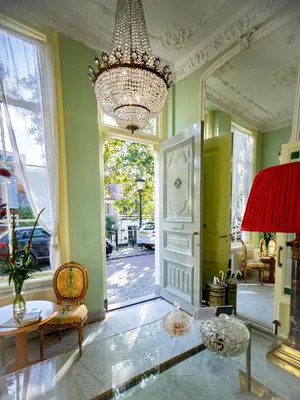 a large room with a large mirror and a chandelier at Boutique Hotel Museumkwartier in Utrecht